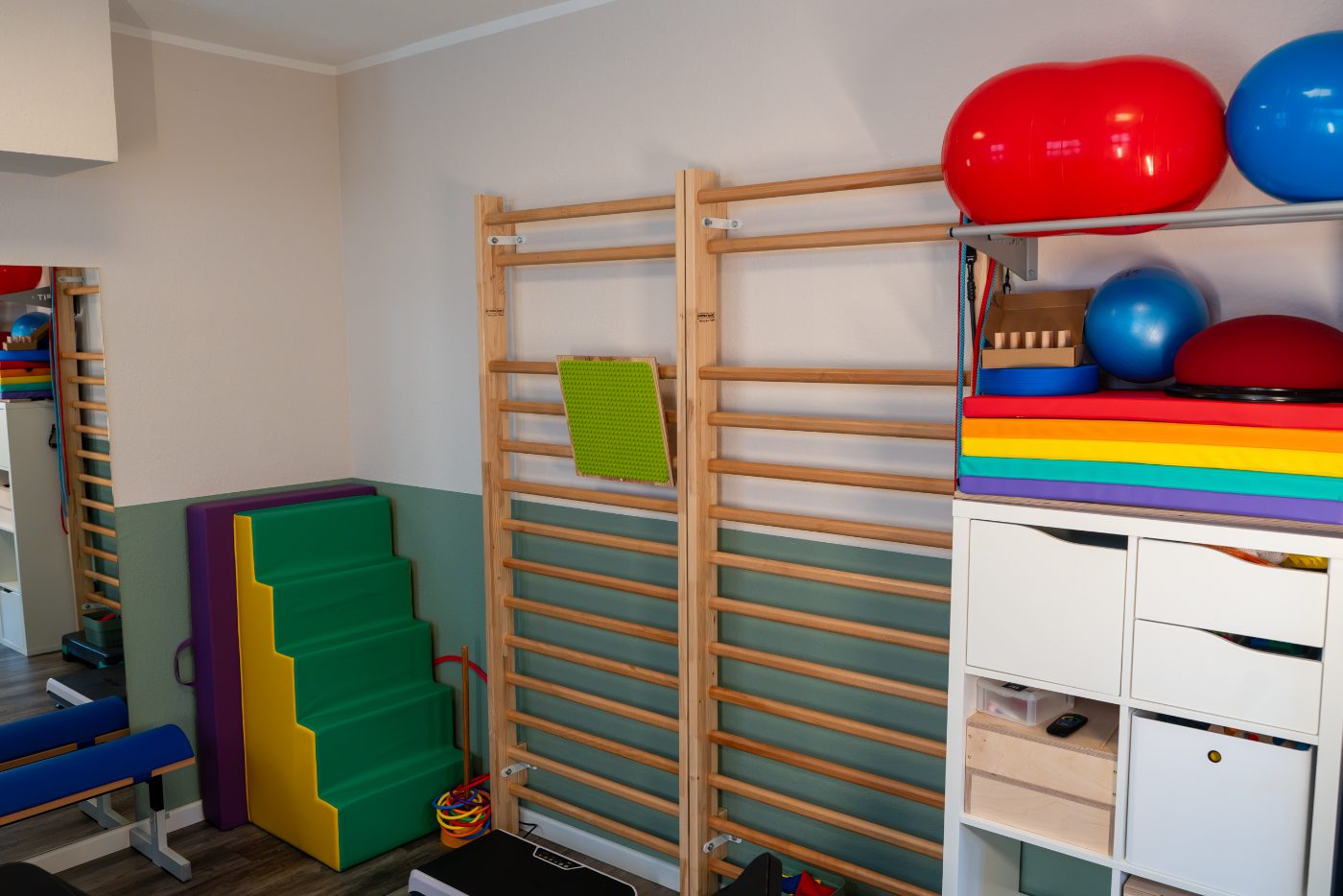 Bewegungsraum mit bunten Turnmatten und Sprossenwand